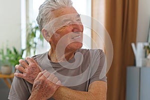 Portrait of senior man with pain in arm.