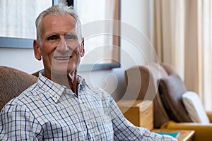 Portrait of senior man relaxing on armchair in nursing home