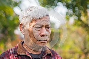 Portrait of a senior man with short gray hair looking away while standing outdoors. Concept of aged people and healthcare