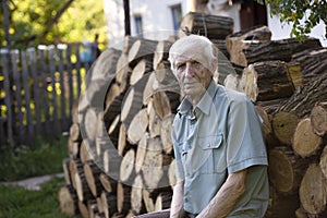 Portrait of  senior man sitting in front of  house