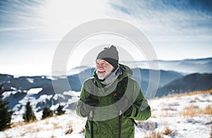 Portrait of senior man standing in snow-covered winter nature.