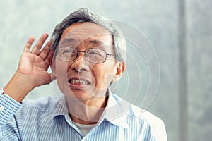 Portrait of senior man to trying hear something sound around him