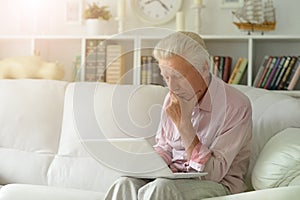 Portrait of senior man using laptop at home