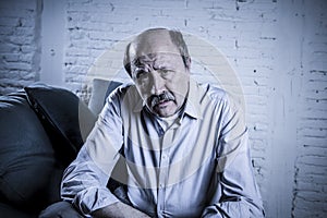 Portrait of senior mature old man on his 60s at home couch alone