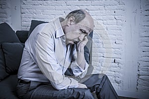 Portrait of senior mature old man on his 60s at home couch alone