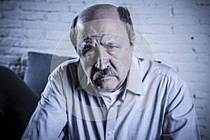 Portrait of senior mature old man on his 60s at home couch alone