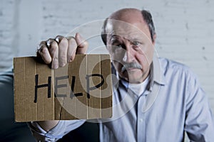 Portrait of senior mature old man on his 60s at home couch alone feeling sad suffering depression asking for help