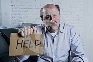 Portrait of senior mature old man on his 60s at home couch alone feeling sad and worried suffering pain and depression