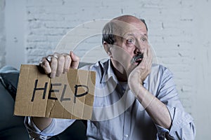 Portrait of senior mature old man on his 60s at home couch alone feeling sad and worried suffering pain and depression