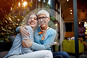 Portrait of a senior mother and adult daughter, hugging, smiling. Love, affection, happiness concept