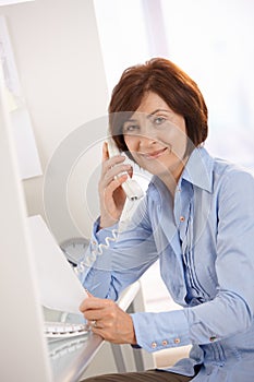 Portrait of senior office worker sitting at desk