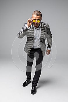 Portrait of senior older business man standing wearing dark sunglasses isolated on white background