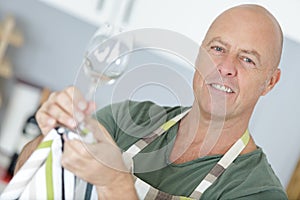 Portrait senior sommelier cleaning glass