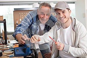 portrait senior tradesman with junior apprentice