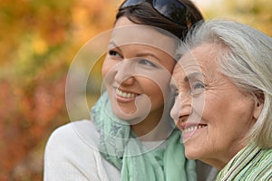 Portrait of senior woman with adult daughter in autumnal park