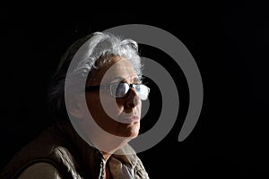 A portrait of a senior woman on black