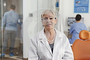 Portrait of senior woman dentist working in stomatological hospital office room