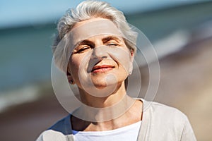 Portrait of senior woman enjoying sun on beach