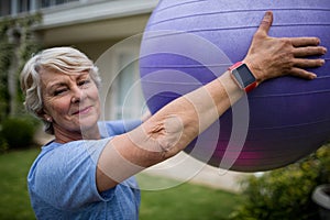 Portrait of senior woman exercising with fitness ball