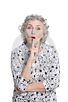 portrait of senior woman gesturing silence isolated on white background