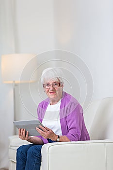 Portrait of a senior woman at home using a tablet computer