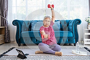 Portrait of senior woman lifting dumbbells extend arms to sides.