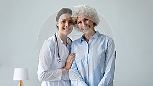 Portrait of senior woman posing with female caregiver