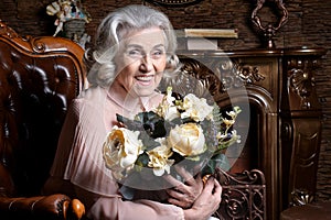 Portrait of senior woman posing with flowers