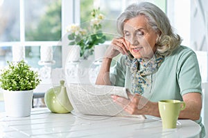 Portrait of senior woman reading newspaper