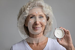 Portrait of senior woman recommend facial cream