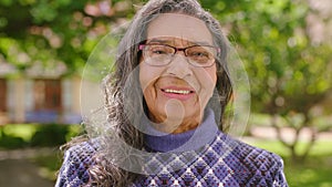 Portrait of senior woman in retirement at park, nature or outdoors breathing in fresh air with bokeh. Face, happiness