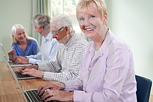 Portrait Of Senior Woman With Tutor In Computer Class