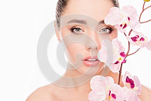 Portrait of sensetive young woman with orchid on white background