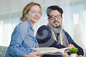 portrait sensible young couple looking at catalogue photo