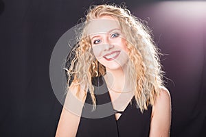 Portrait of sensual blond woman with curly hair over light grey background with copy space