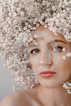 Portrait of sensual blond woman with flowers. Beautiful girl with flowers in her hair. Summer Beauty. Art in a