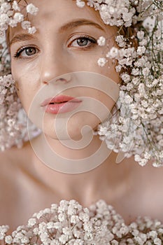Portrait of sensual blond woman with flowers. Beautiful girl with flowers in her hair. Summer Beauty. Art in a