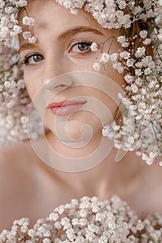 Portrait of sensual blond woman with flowers. Beautiful girl with flowers in her hair. Summer Beauty. Art in a