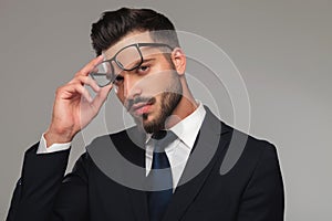 Portrait of sensual businessman taking eyeglasses off