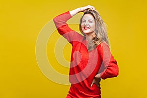 Portrait of sensual happy blonde woman with red lipstick in bright casual sweater, isolated on yellow background