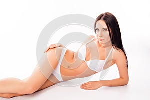 Portrait of sensual pretty healthy woman lying in white underwear