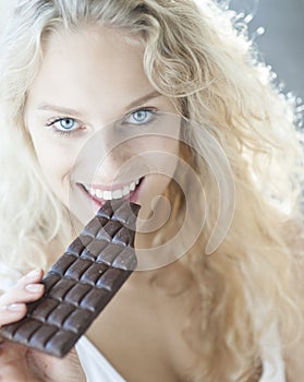 Portrait of sensuous woman eating chocolate bar
