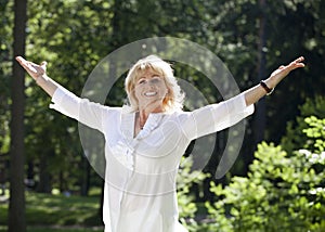 Portrait of serene mature woman in the summer park