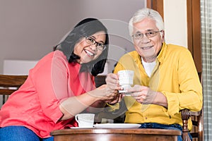 Portrait of serene senior couple enjoying a cup of coffee at hom