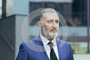 Portrait of serios senior businessman man with gray hair and brown hair in business suit with tie