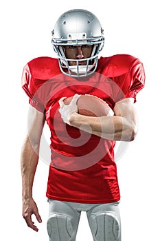 Portrait of serious American football player in red jersey holding ball