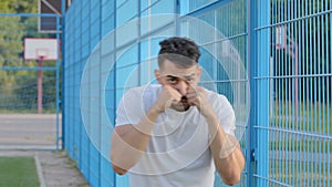 Portrait serious angry tense Middle eastern indian boxer pounding air with clenched fist. Young Arabic male athlete in