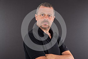 Portrait of serious arms crossed mature man on grey background