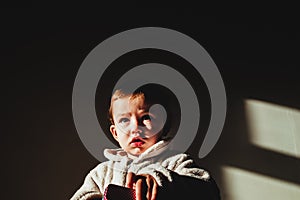 Portrait of serious baby isolated with dark background