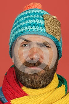 Portrait of serious bearded man in colorful scarf and woolen hat. Casual look. Fashionable man in winter clothes. Men